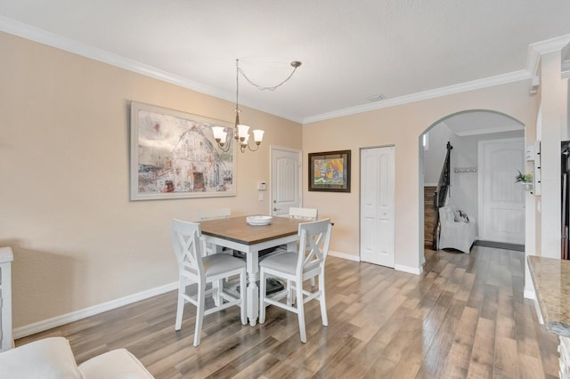 5014 Manchia Dr, Lake Worth, FL 33463 - dining area with arched walkways, light wood finished floors, baseboards, a chandelier, and ornamental molding