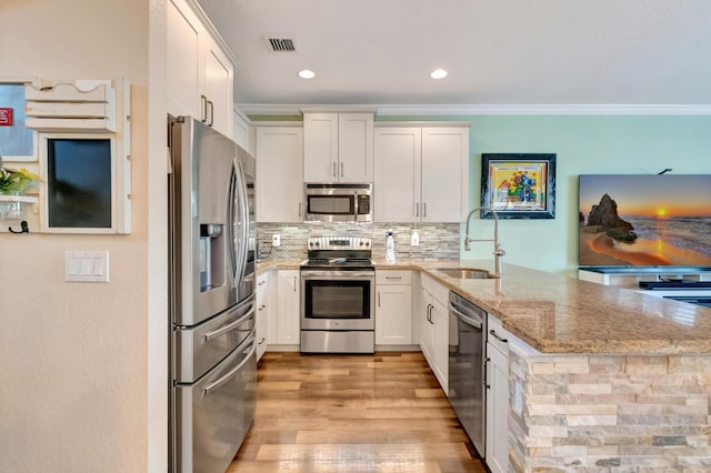 5014 Manchia Dr, Lake Worth, FL 33463 - kitchen with stainless steel appliances, a sink, a peninsula, light stone counters, and crown molding