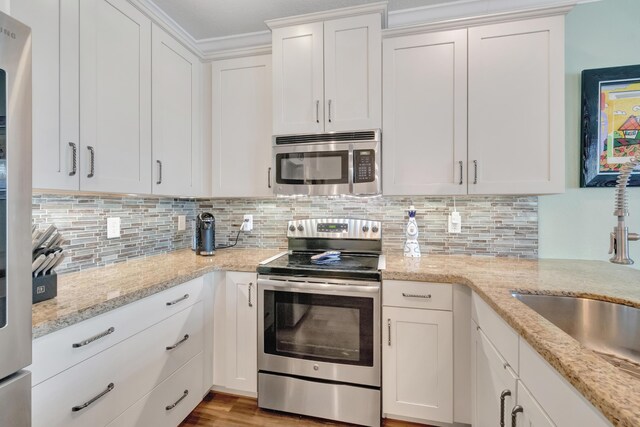 5014 Manchia Dr, Lake Worth, FL 33463 - kitchen with appliances with stainless steel finishes, white cabinets, decorative backsplash, and light stone counters