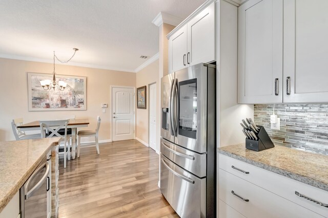5014 Manchia Dr, Lake Worth, FL 33463 - kitchen with stainless steel fridge with ice dispenser, ornamental molding, a chandelier, tasteful backsplash, and white cabinetry