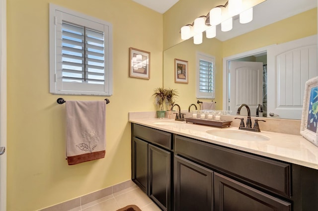 5014 Manchia Dr, Lake Worth, FL 33463 - bathroom with double vanity, tile patterned floors, healthy amount of natural light, and baseboards