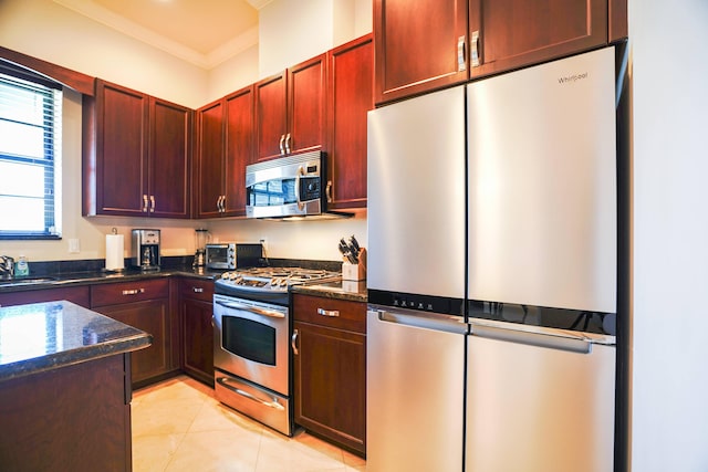 65 NE 4th Ave Unit I, Delray Beach, FL 33483 - kitchen with stainless steel appliances, dark stone countertops, a sink, dark brown cabinets, and light tile patterned floors