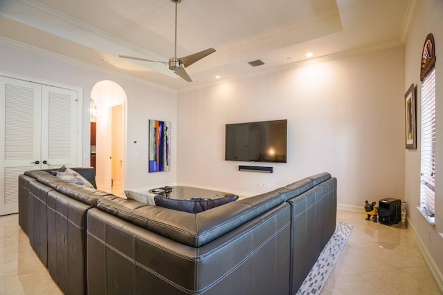 65 NE 4th Ave Unit I, Delray Beach, FL 33483 - living area featuring a tray ceiling, baseboards, arched walkways, crown molding, and light tile patterned floors