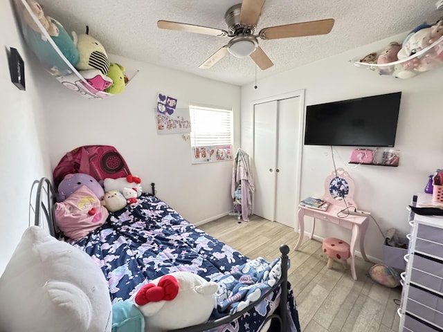 308 Florida Ave, Winter Garden, FL 34787 - bedroom featuring wood finished floors, a textured ceiling, a closet, a ceiling fan, and baseboards