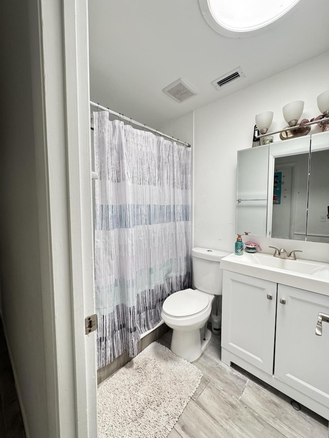 308 Florida Ave, Winter Garden, FL 34787 - bathroom with toilet, vanity, wood finished floors, and curtained shower