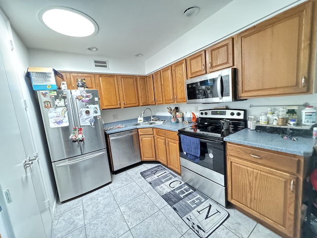308 Florida Ave, Winter Garden, FL 34787 - kitchen featuring appliances with stainless steel finishes, a sink, light tile patterned flooring, and brown cabinets