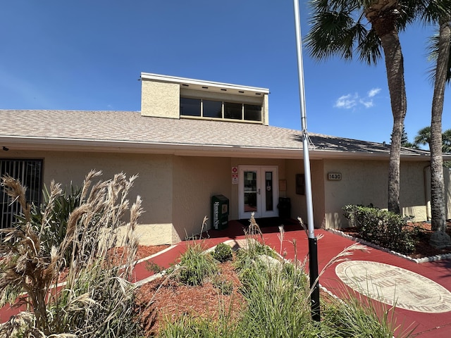 1021 Abada Ct NE Unit 106, Palm Bay, FL 32905 - view of front of property featuring stucco siding, french doors, and roof with shingles