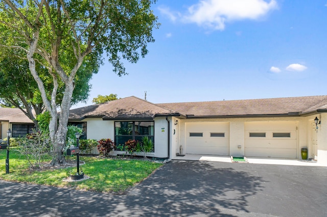 4657 Greentree Pl Unit A, Boynton Beach, FL 33436 - ranch-style home with asphalt driveway, stucco siding, a garage, a shingled roof, and a front lawn