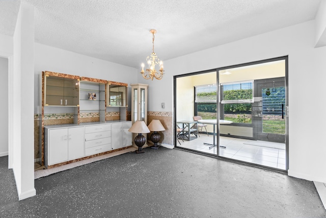 4657 Greentree Pl Unit A, Boynton Beach, FL 33436 - unfurnished dining area featuring a chandelier, a textured ceiling, baseboards, and speckled floor