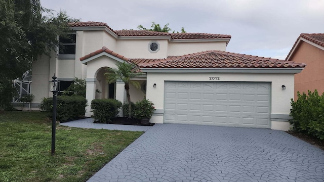 2012 White Coral Ct, Wellington, FL 33414 - mediterranean / spanish home featuring a garage, driveway, a front lawn, stucco siding, and a tile roof