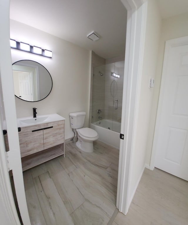 2012 White Coral Ct, Wellington, FL 33414 - bathroom featuring shower / bath combination with glass door, vanity, toilet, and wood finished floors