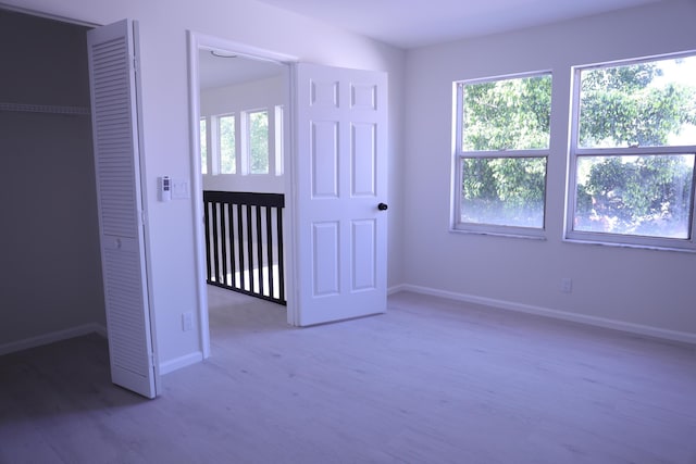 2012 White Coral Ct, Wellington, FL 33414 - unfurnished bedroom featuring multiple windows, wood finished floors, and baseboards