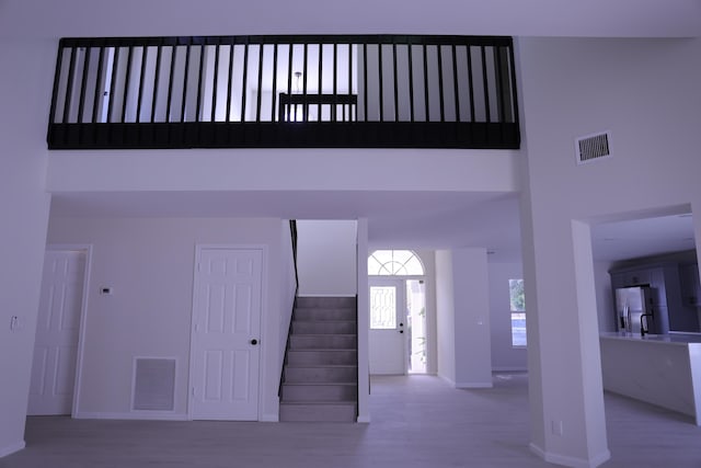 2012 White Coral Ct, Wellington, FL 33414 - staircase featuring a high ceiling, wood finished floors, and baseboards