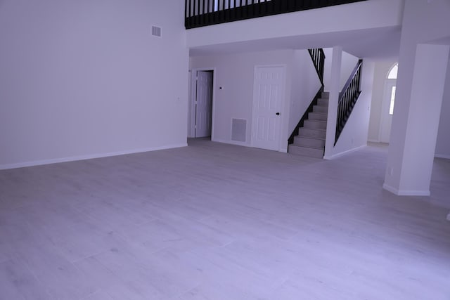 2012 White Coral Ct, Wellington, FL 33414 - unfurnished living room with stairway, wood finished floors, a towering ceiling, and baseboards