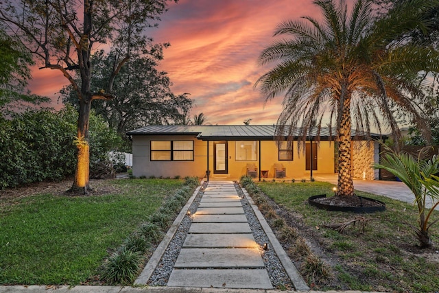 1646 NE 3rd Ave, Delray Beach, FL 33444 - view of front of property with stucco siding, a standing seam roof, a front yard, and metal roof