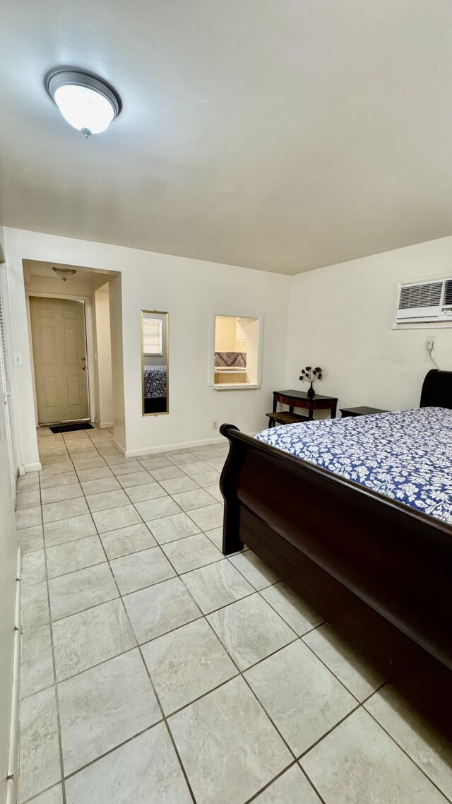 629 Troy Blvd, West Palm Beach, FL 33409 - bedroom with a wall mounted AC, light tile patterned floors, and baseboards