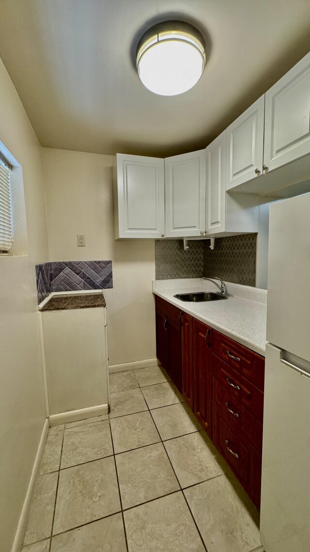 629 Troy Blvd, West Palm Beach, FL 33409 - kitchen featuring freestanding refrigerator, baseboards, a sink, light countertops, and light tile patterned floors