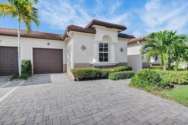 14811 Via Porta, Delray Beach, FL 33446 - mediterranean / spanish-style house with decorative driveway, stucco siding, an attached garage, and a tiled roof