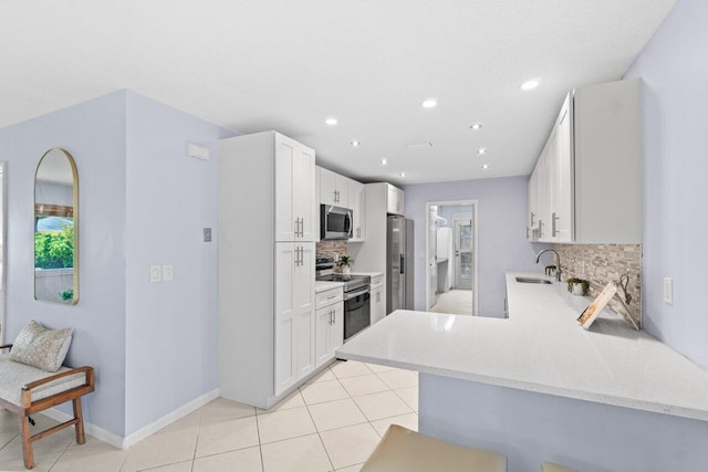 3187 Buccaneer Rd, Lake Worth, FL 33462 - kitchen featuring appliances with stainless steel finishes, decorative backsplash, a sink, a peninsula, and light stone counters
