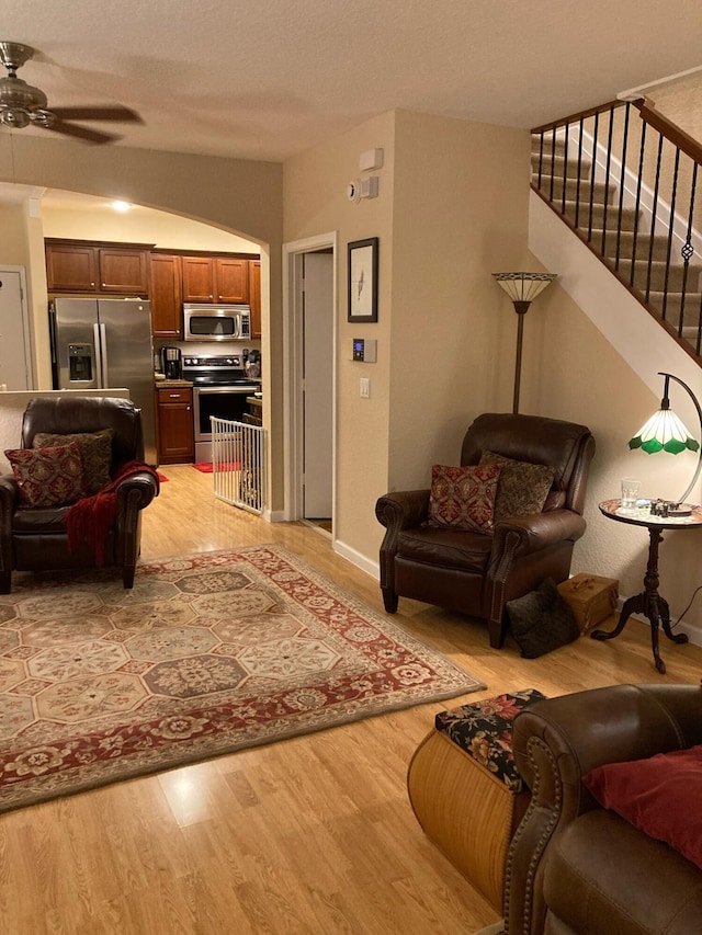 1428 W Wickham C Cir Unit C, Delray Beach, FL 33445 - living area featuring light wood-style flooring, ceiling fan, stairway, and arched walkways