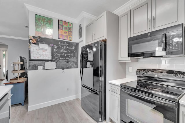 212 River Bluff Ln, Royal Palm Beach, FL 33411 - kitchen with black appliances, crown molding, light countertops, light wood-style floors, and arched walkways