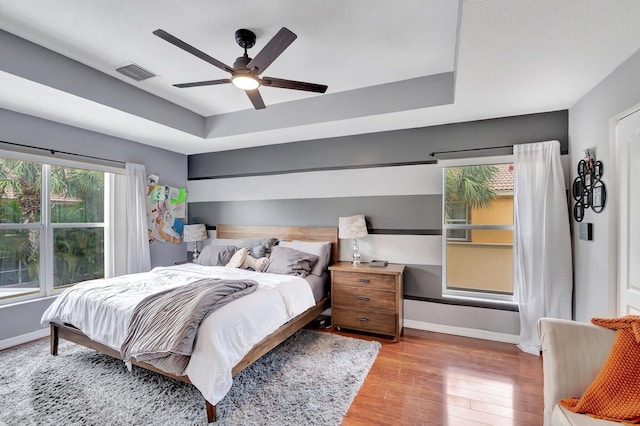 212 River Bluff Ln, Royal Palm Beach, FL 33411 - bedroom featuring baseboards, wood finished floors, a raised ceiling, and ceiling fan
