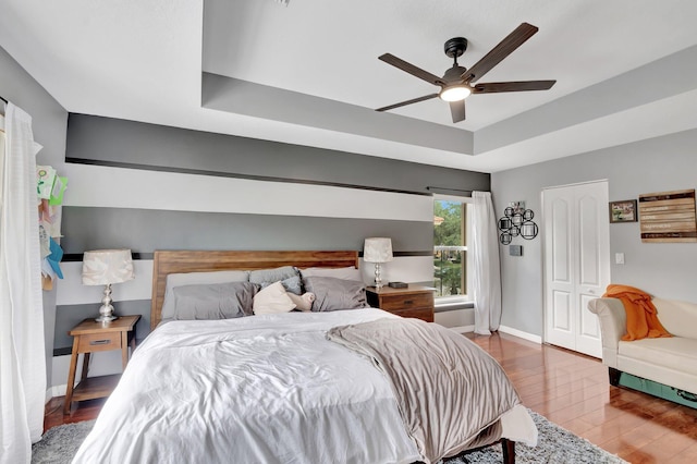 212 River Bluff Ln, Royal Palm Beach, FL 33411 - bedroom with a raised ceiling, wood finished floors, baseboards, and a ceiling fan