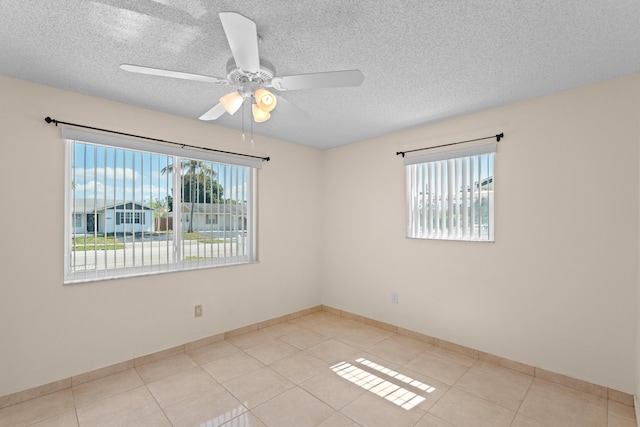 5082 Grant Ln, West Palm Beach, FL 33415 - tiled spare room featuring a textured ceiling, a ceiling fan, and baseboards