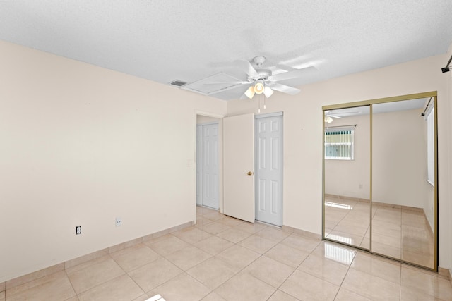 5082 Grant Ln, West Palm Beach, FL 33415 - unfurnished bedroom featuring light tile patterned flooring, ceiling fan, a closet, and a textured ceiling