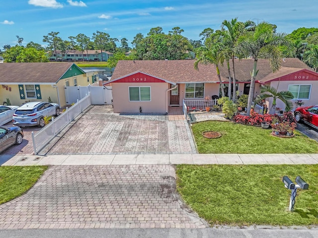 5082 Grant Ln, West Palm Beach, FL 33415 - single story home featuring stucco siding, covered porch, decorative driveway, and roof with shingles