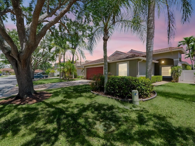 6287 Grand Cypress Cir, Lake Worth, FL 33463 - view of front of property with stucco siding, a garage, concrete driveway, and a yard