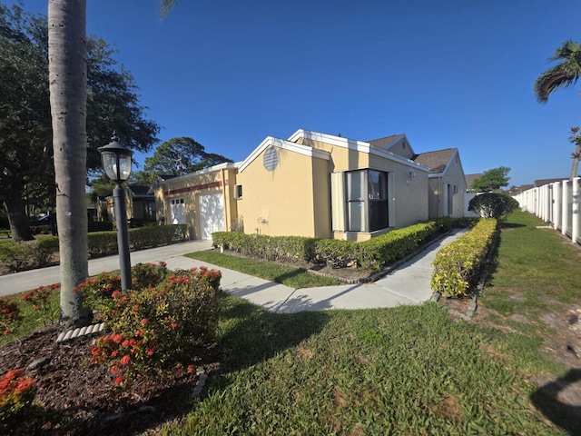 4580 Discovery Ln Unit 23, West Palm Beach, FL 33417 - view of side of home featuring stucco siding, a garage, and driveway