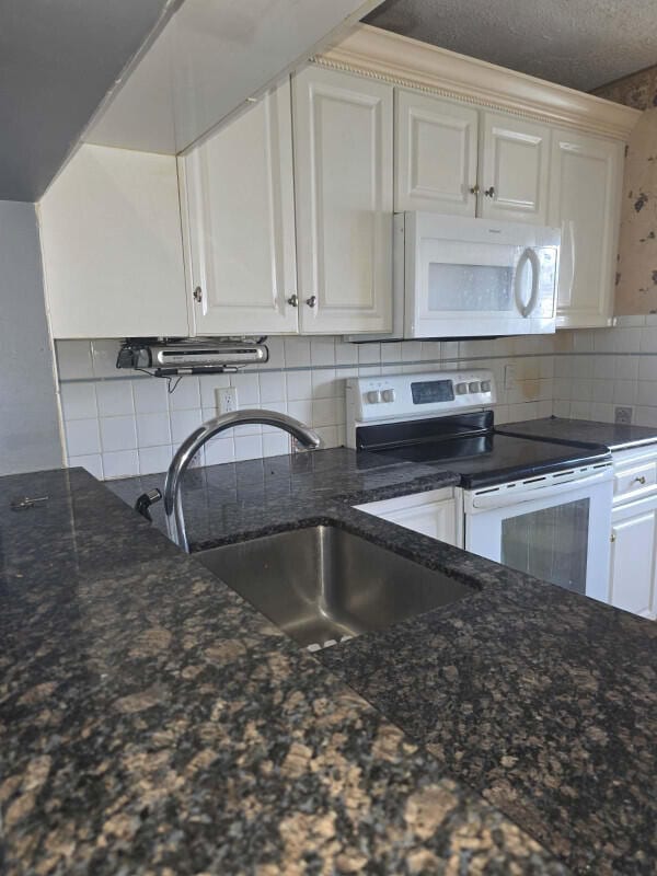 4580 Discovery Ln Unit 23, West Palm Beach, FL 33417 - kitchen with white microwave, electric range, a sink, and decorative backsplash