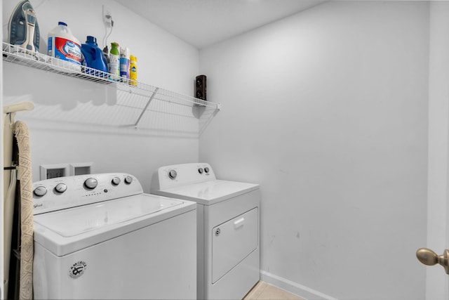 6340 Sailpointe Ln, West Palm Beach, FL 33413 - washroom featuring washing machine and clothes dryer, baseboards, and light tile patterned floors