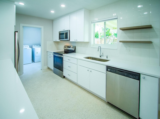 214 SW 3rd St, Boca Raton, FL 33432 - kitchen featuring appliances with stainless steel finishes, a sink, washing machine and dryer, white cabinets, and tasteful backsplash