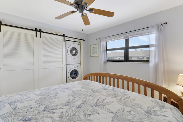 755 Saturn St Unit E 202, Jupiter, FL 33477 - bedroom featuring stacked washing machine and dryer, a barn door, and a ceiling fan