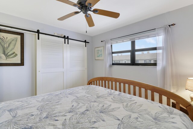 755 Saturn St Unit E 202, Jupiter, FL 33477 - bedroom featuring a barn door and a ceiling fan