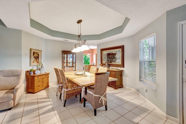 11650 Briarwood Cir Unit 2, Boynton Beach, FL 33437 - dining room with a tray ceiling, a textured ceiling, baseboards, light tile patterned floors, and a chandelier