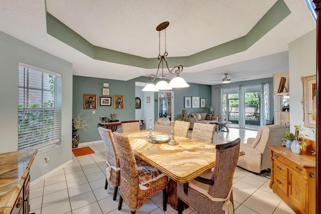11650 Briarwood Cir Unit 2, Boynton Beach, FL 33437 - dining area featuring light tile patterned floors, a textured ceiling, a tray ceiling, baseboards, and a ceiling fan