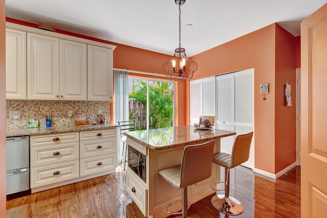 11650 Briarwood Cir Unit 2, Boynton Beach, FL 33437 - kitchen with black microwave, a chandelier, dishwasher, light stone countertops, and a breakfast bar area