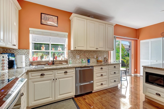 11650 Briarwood Cir Unit 2, Boynton Beach, FL 33437 - kitchen with a sink, stainless steel dishwasher, light wood-style flooring, tasteful backsplash, and light stone countertops