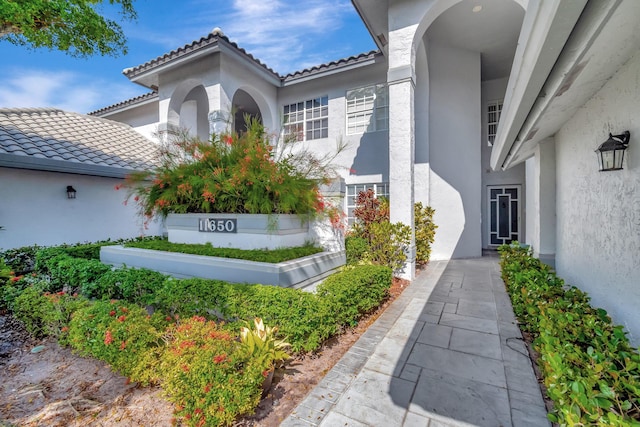 11650 Briarwood Cir Unit 2, Boynton Beach, FL 33437 - view of exterior entry featuring stucco siding and a tile roof