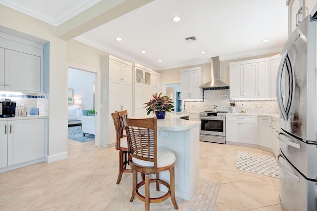 3321 Southern Cay Dr, Jupiter, FL 33477 - kitchen featuring appliances with stainless steel finishes, wall chimney exhaust hood, backsplash, a kitchen bar, and light countertops