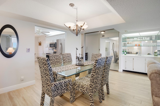 3326 Arcara Way Unit 416, Lake Worth, FL 33467 - dining area with a chandelier, light wood-style floors, baseboards, a ceiling fan, and a tray ceiling