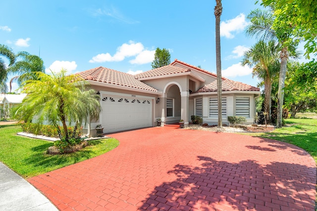 10560 Plainview Cir, Boca Raton, FL 33498 - mediterranean / spanish home with an attached garage, decorative driveway, a tiled roof, stucco siding, and a front yard