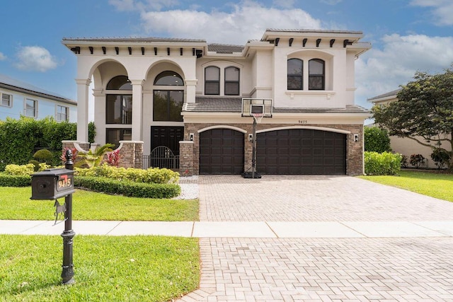 9475 Equus Cir, Boynton Beach, FL 33472 - mediterranean / spanish home with an attached garage, decorative driveway, a front yard, and stucco siding