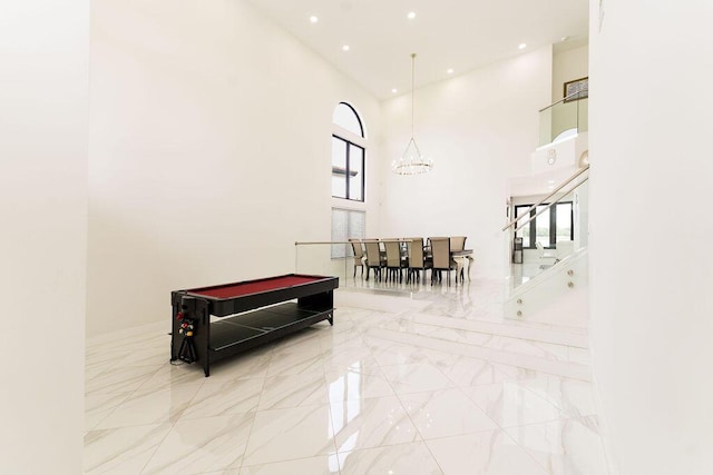 9475 Equus Cir, Boynton Beach, FL 33472 - corridor with marble tiled flooring, a towering ceiling, a chandelier, recessed lighting, and baseboards