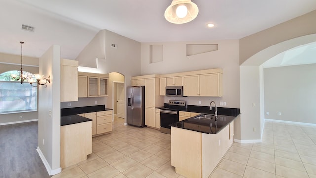 5170 NW Aljo Ct, Port Saint Lucie, FL 34986 - kitchen featuring stainless steel appliances, light brown cabinetry, a sink, a peninsula, and high vaulted ceiling