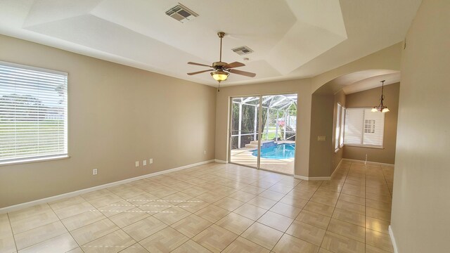 5170 NW Aljo Ct, Port Saint Lucie, FL 34986 - unfurnished room featuring a raised ceiling, arched walkways, ceiling fan, and baseboards