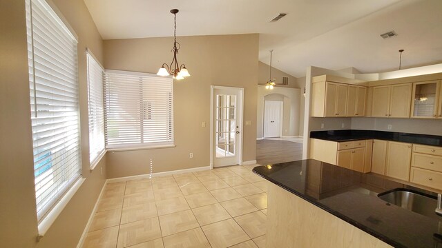5170 NW Aljo Ct, Port Saint Lucie, FL 34986 - kitchen featuring vaulted ceiling, arched walkways, light brown cabinets, dark countertops, and baseboards